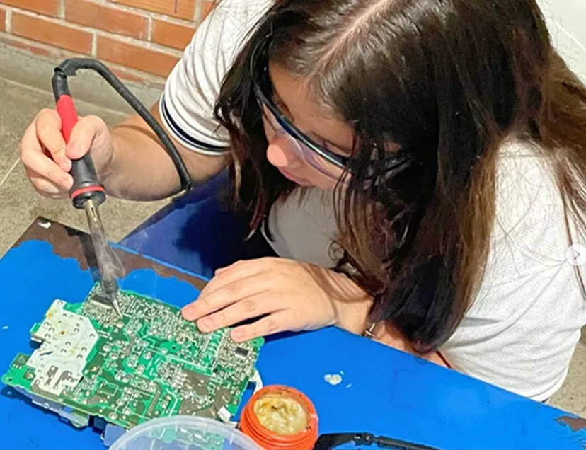 Aluna soldando uma placa eletrônica em uma aula prática